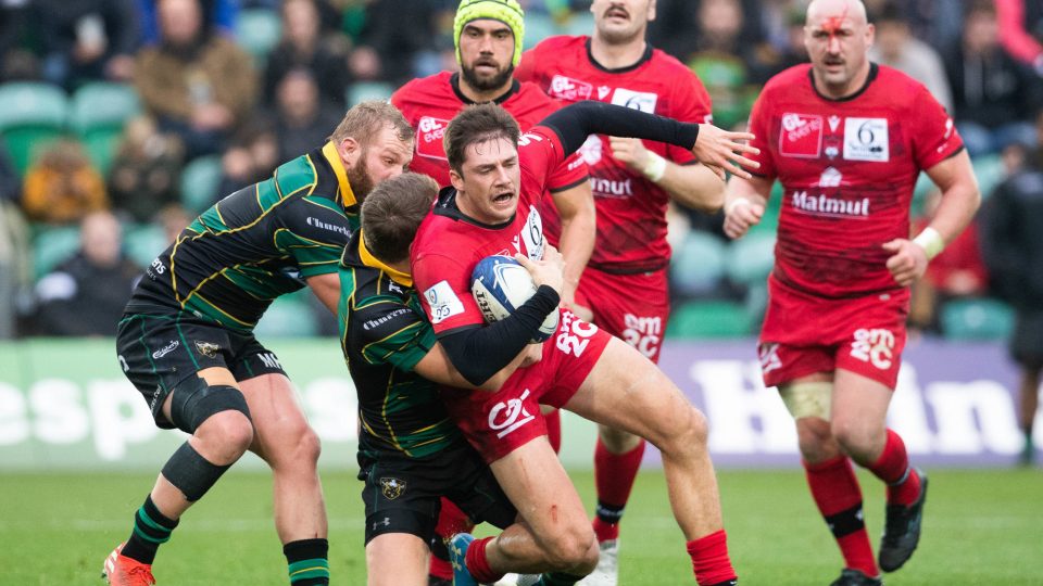 Lyon's Pierre-Louis Barassi is tackled by Northampton Saints' Dan Biggar uring the Pool One match of the Heineken Champions Cup at Franklins Gardens, Northampton.