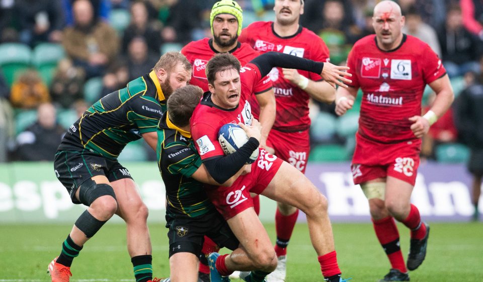 Lyon's Pierre-Louis Barassi is tackled by Northampton Saints' Dan Biggar uring the Pool One match of the Heineken Champions Cup at Franklins Gardens, Northampton.